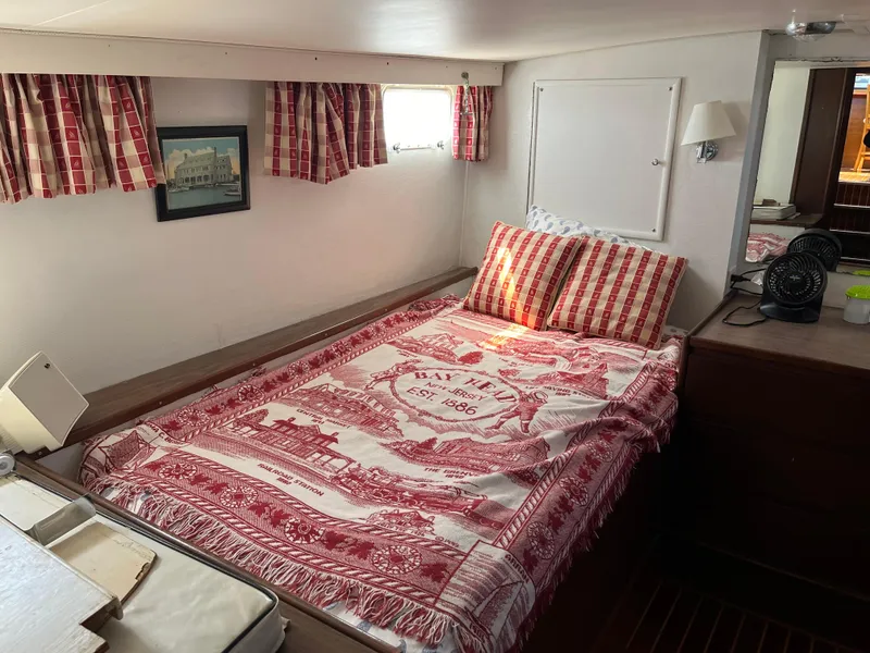Slide: The Image of 1970 Matthews Flush Deck Cruiser cabin with red plaid decor and cozy bedding. - 30