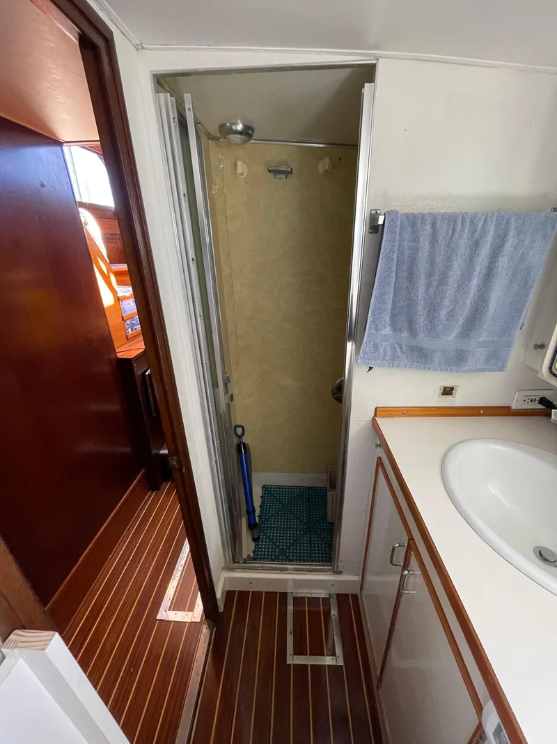 Slide: The Image of 1970 Matthews Flush Deck Cruiser bathroom with shower, sink, and wooden flooring. - 39