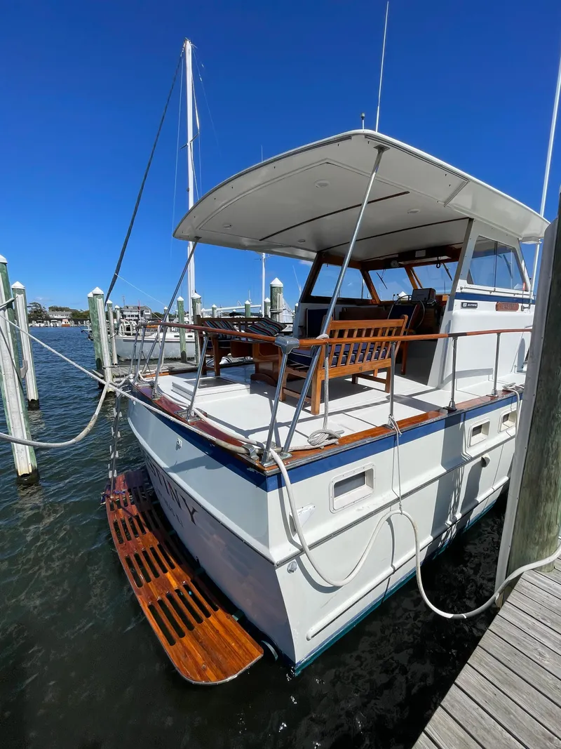 Slide: The Image of 1970 Matthews Flush Deck Cruiser docked at marina under clear blue sky. - 9
