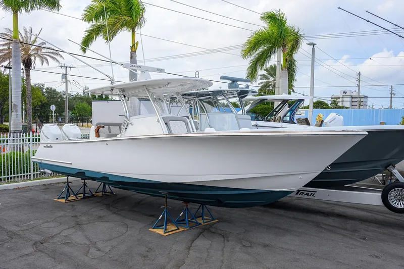 Slide: The Image of 2020 Valhalla Boatworks V-33 on stands, surrounded by palm trees. - 2