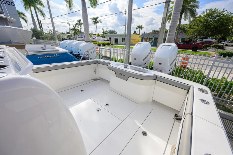 Slide: The Image of 2020 Valhalla V-33 boat deck with twin Mercury outboard engines, surrounded by palm trees. - 20