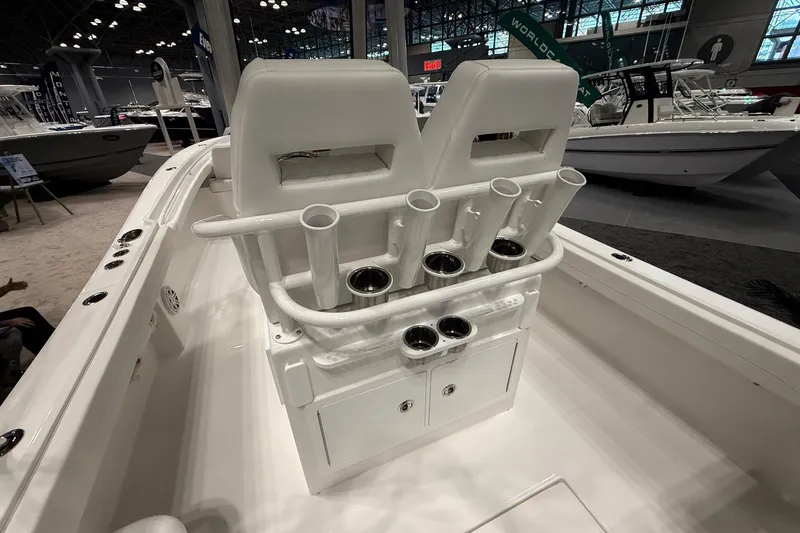 Slide: The Image of 2026 Regulator 23 boat interior with rod holders and seating at a boat show. - 14