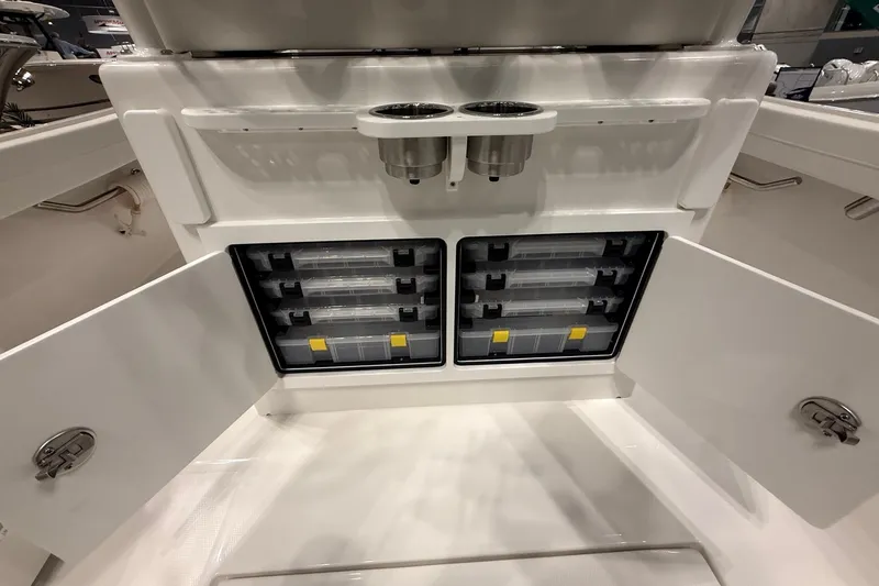 Slide: The Image of 2026 Regulator 23 boat storage compartments with tackle boxes and cup holders. - 15