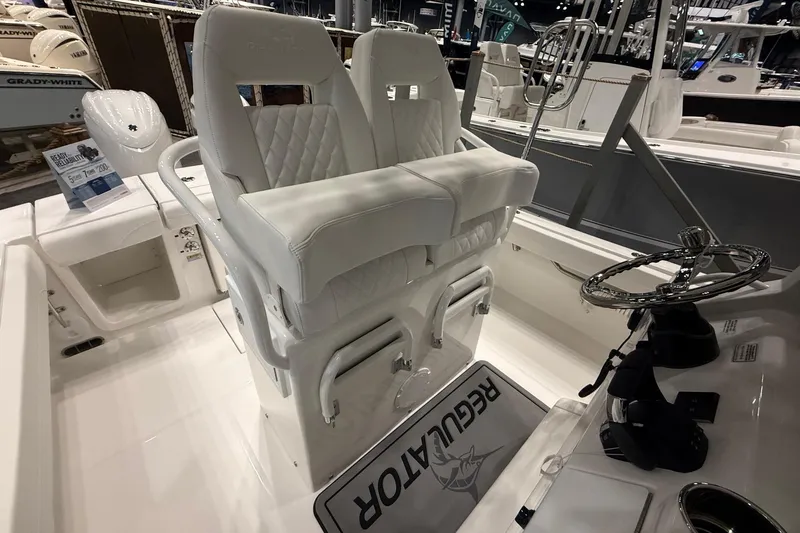 Slide: The Image of 2026 Regulator 23 boat interior with white seating and steering wheel. - 18