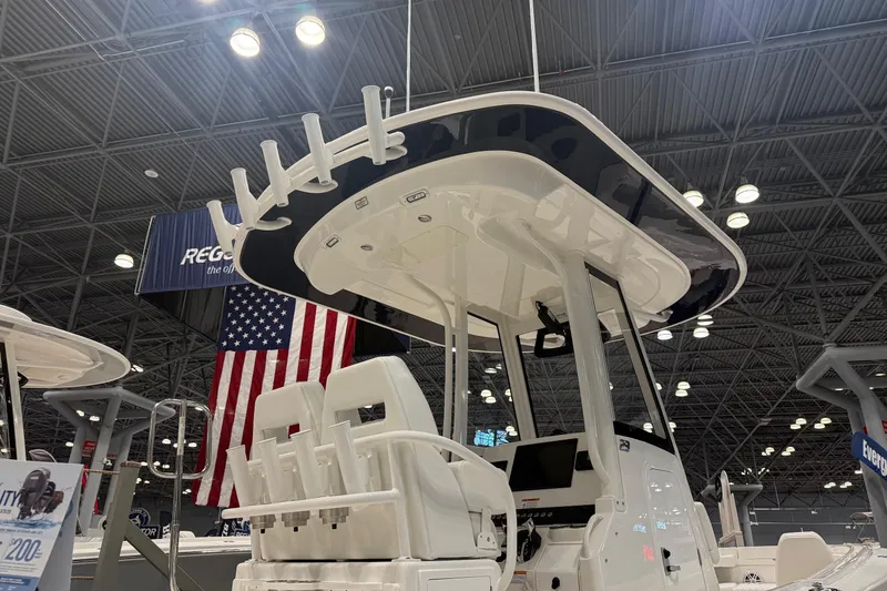 Slide: The Image of 2026 Regulator 23 boat interior at a boat show, featuring modern design and American flag backdrop. - 2