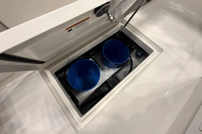 Slide: The Image of Storage compartment with blue buckets on a 2026 Regulator 23 boat. - 21