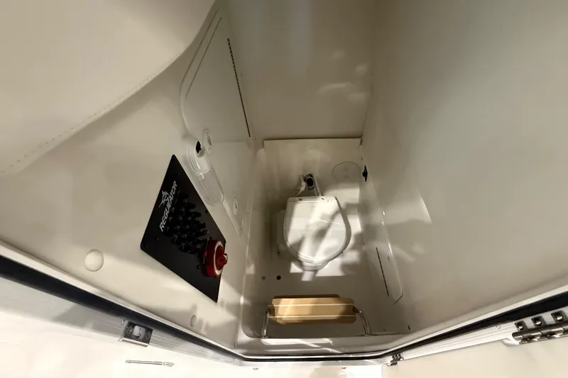 Slide: The Image of 2026 Regulator 23 boat interior with control panel and compact toilet. - 23