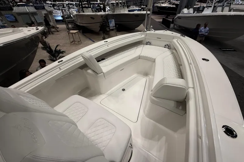 Slide: The Image of 2026 Regulator 23 boat interior with white seating and modern design at a boat show. - 24