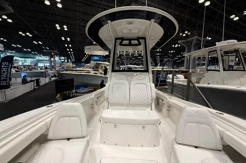 Slide: The Image of 2026 Regulator 23 boat interior at a boat show, featuring white seating and modern design. - 30
