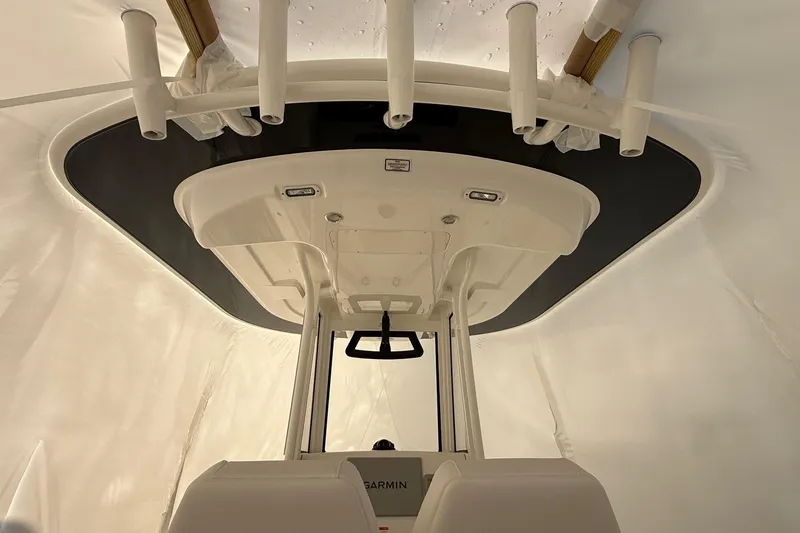 Slide: The Image of 2026 Regulator 23 boat interior with T-top and rod holders, featuring Garmin electronics. - 39
