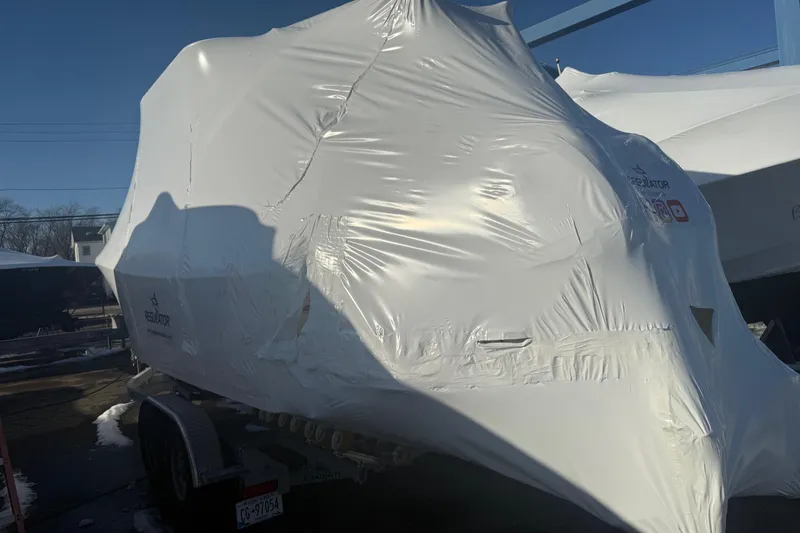 Slide: The Image of 2026 Regulator 23 boat covered in protective wrap on a trailer. - 64