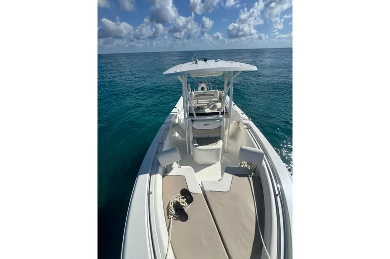 Slide: The Image of 2013 Sea Hunt Ultra 234 boat on open water under a partly cloudy sky. - 5