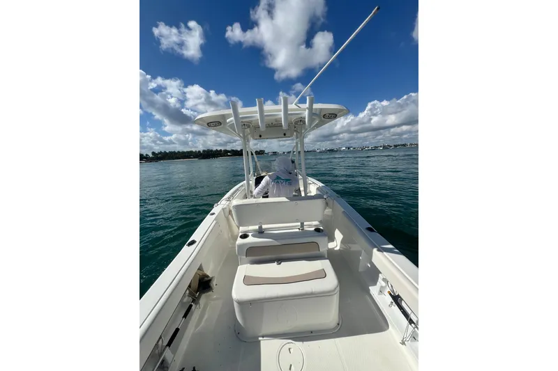 Slide: The Image of 2013 Sea Hunt Ultra 234 boat on calm water under a blue sky. - 9