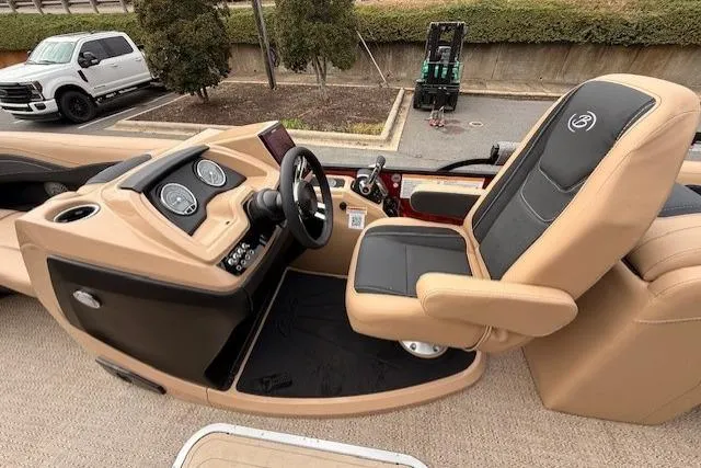 Slide: The Image of 2026 Barletta C22QC boat interior with tan and black captain's chair and dashboard controls. - 11