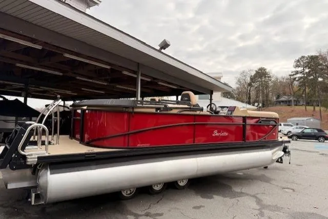 Slide: The Image of 2026 Barletta C22QC pontoon boat with red exterior, parked under a shelter. - 12