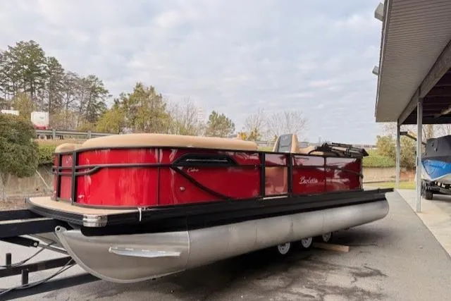 Slide: The Image of 2026 Barletta C22QC pontoon boat with red exterior on a trailer. - 14
