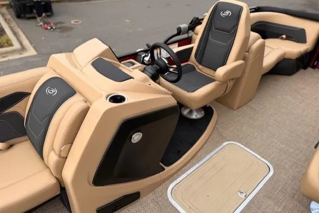 Slide: The Image of 2026 Barletta C22QC boat interior with tan and black seating, steering wheel, and carpeted floor. - 4