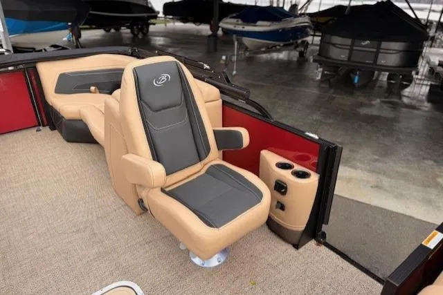 Slide: The Image of 2026 Barletta C22QC boat interior with tan and gray seating, cup holders, and carpeted flooring. - 5