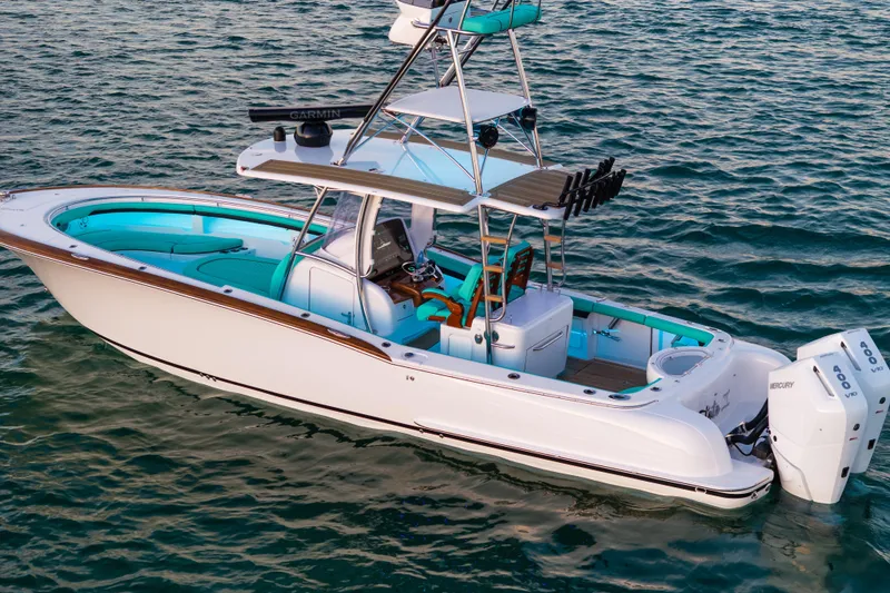 Slide: The Image of 2019 Mag Bay 33 CC boat on water, featuring sleek design and twin Mercury engines. - 12