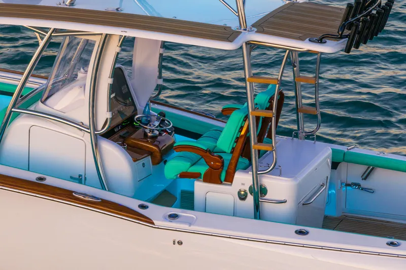 Slide: The Image of 2019 Mag Bay 33 CC boat interior with turquoise seating and wooden accents on the water. - 13