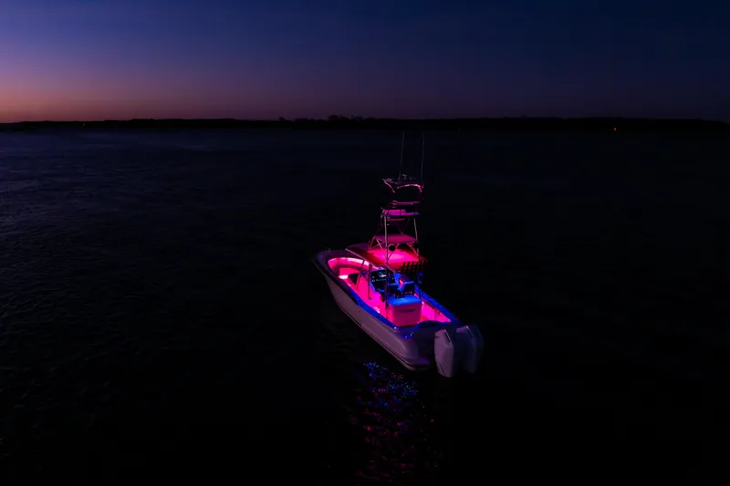 Slide: The Image of 2019 Mag Bay 33 CC boat illuminated at night on calm water. - 19