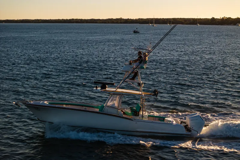 Slide: The Image of 2019 Mag Bay 33 CC boat cruising on open water at sunset. - 23