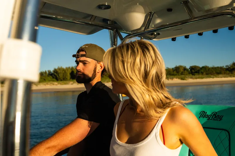 Slide: The Image of Couple enjoying a ride on a 2019 Mag Bay 33 CC boat. - 28