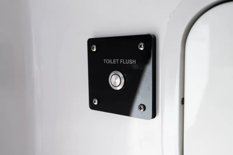 Slide: The Image of Toilet flush button on 2019 Mag Bay 33 CC boat interior. - 45