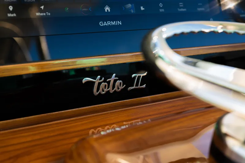 Slide: The Image of 2019 Mag Bay 33 CC dashboard with Garmin display and "Toto II" nameplate. - 62