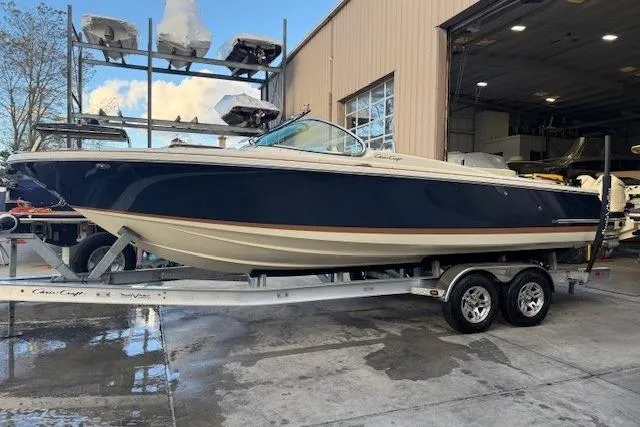 The Image of 2022 Chris-Craft Launch 25 GT boat on trailer outside a warehouse. - 1