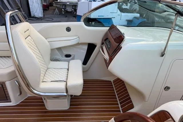 Slide: The Image of 2022 Chris-Craft Launch 25 GT interior with white quilted seats and wooden flooring. - 15