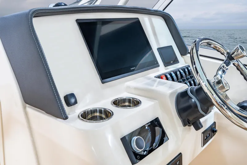 Slide: The Image of 2026 Grady-White Freedom 285 boat dashboard with steering wheel and control panel. - 3