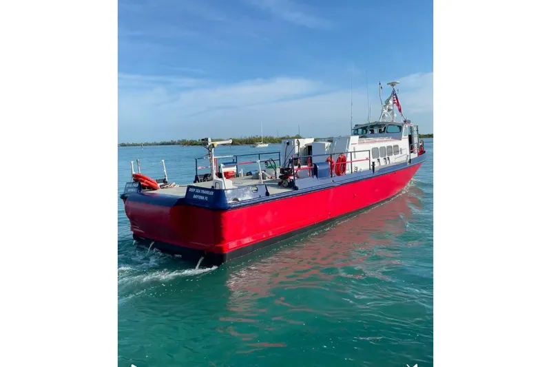 Slide: The Image of Red and blue 1964 custom commercial boat on calm water under clear sky. - 2