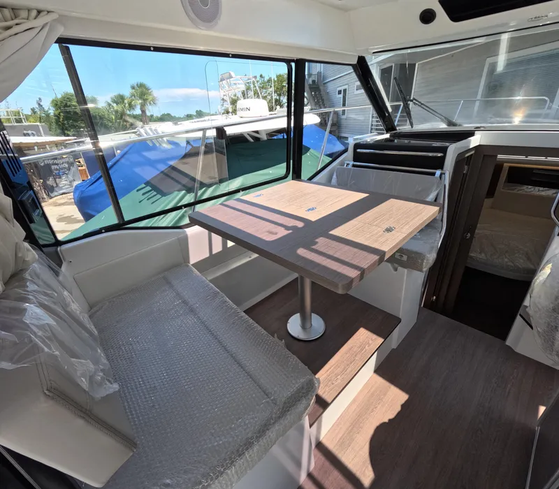 Slide: The Image of Interior of 2024 Jeanneau NC Weekender 895 Series 2, featuring dining area with table and seating. - 3