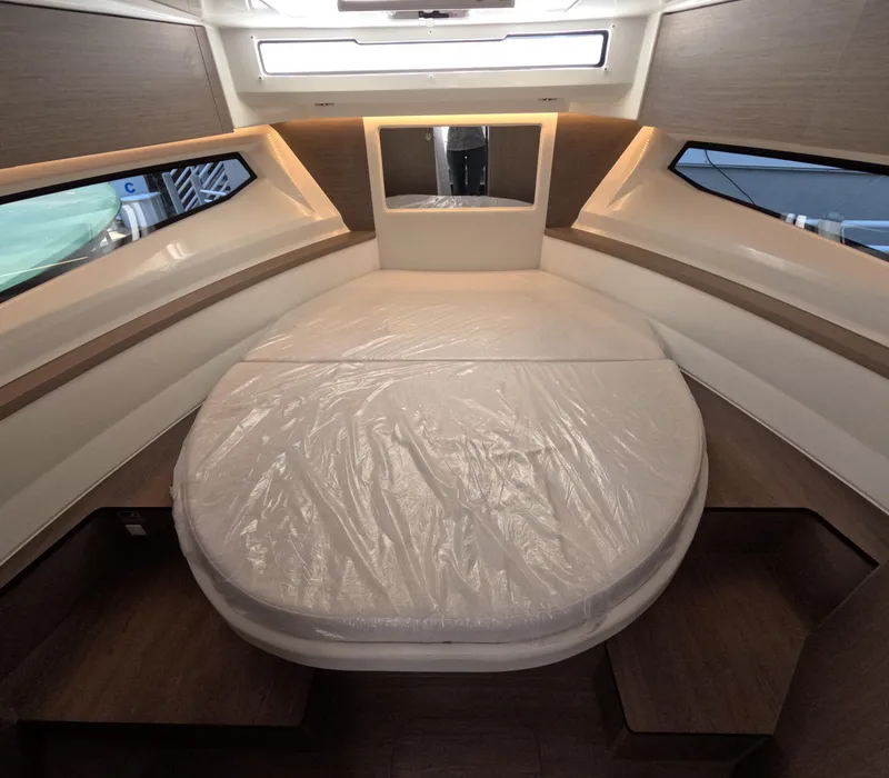 Slide: The Image of 2024 Jeanneau NC Weekender 895 Series 2 cabin interior with bed and windows. - 6
