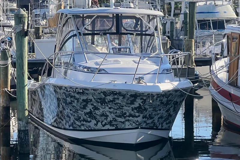 The Image of 2008 Pro-Line 32 Express boat with camouflage design docked at marina. - 0