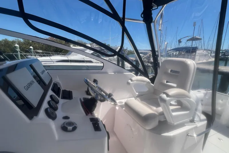 Slide: The Image of 2008 Pro-Line 32 Express boat cockpit with Garmin navigation, white captain's chair, and marina view. - 10