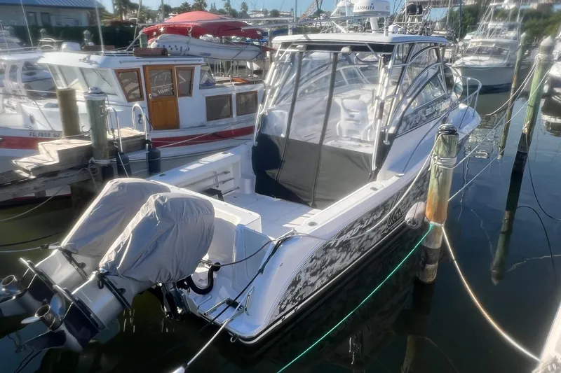 Slide: The Image of 2008 Pro-Line 32 Express boat docked at marina, featuring covered outboard motors. - 2