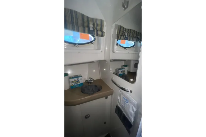 Slide: The Image of 2008 Pro-Line 32 Express boat bathroom with sink, mirror, and porthole window. - 20