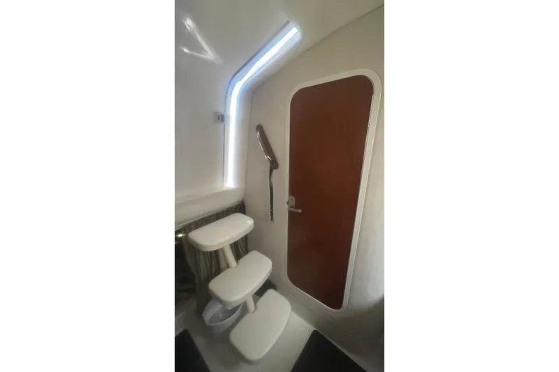 Slide: The Image of 2008 Pro-Line 32 Express boat bathroom with sink, mirror, and porthole window. - 23