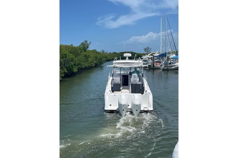 Slide: The Image of 2008 Pro-Line 32 Express boat navigating a narrow waterway with lush greenery. - 7