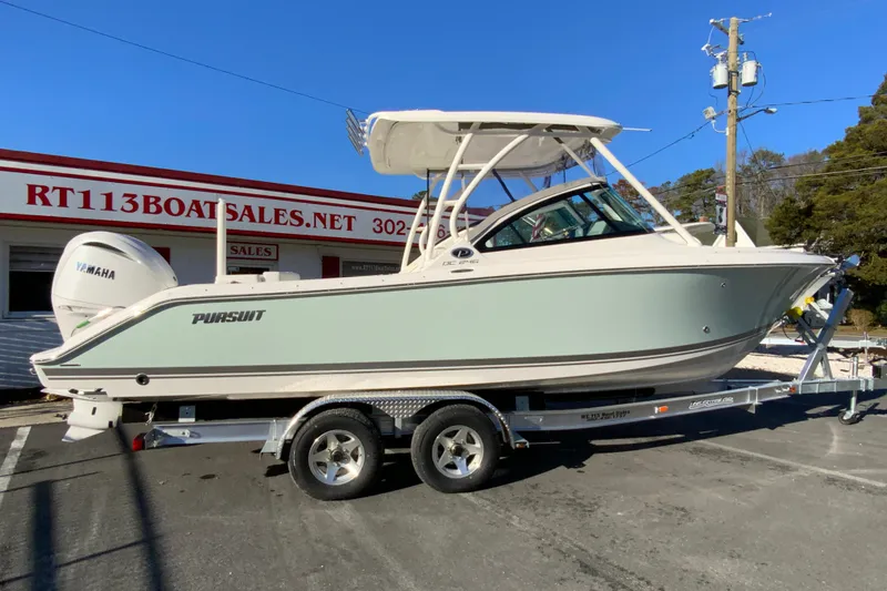 The Image of 2026 Pursuit DC 246 Dual Console boat on trailer at dealership. - 1
