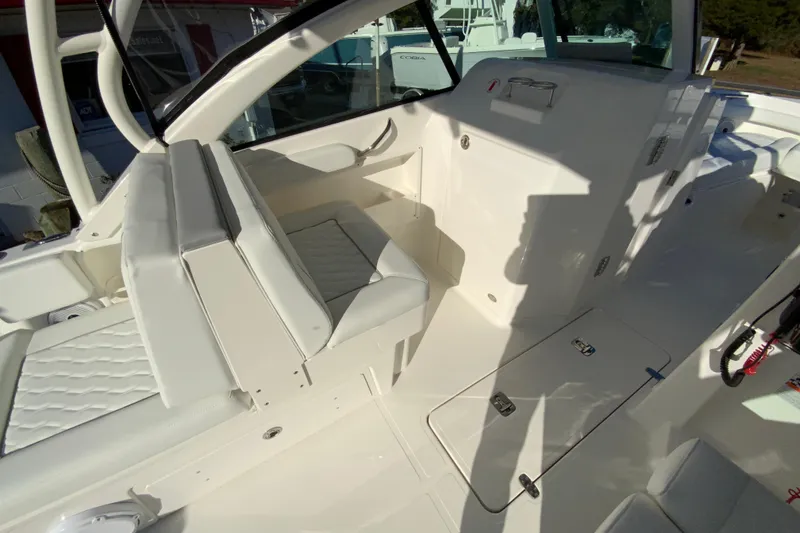 Slide: The Image of 2026 Pursuit DC 246 Dual Console interior with white seating and storage compartments. - 13