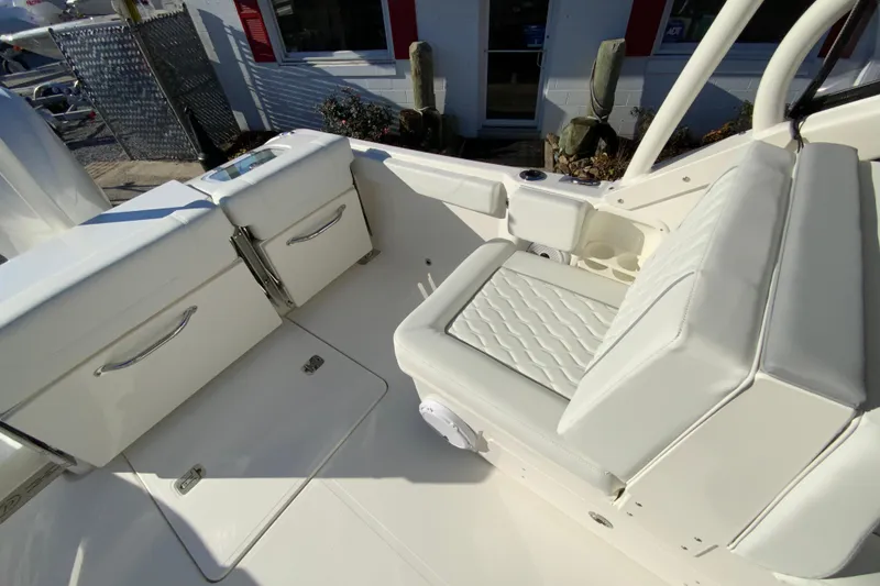 Slide: The Image of 2026 Pursuit DC 246 Dual Console boat interior with white seating and storage compartments. - 14