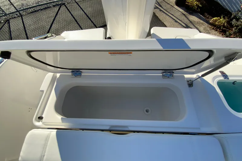 Slide: The Image of Open storage compartment on 2026 Pursuit DC 246 Dual Console boat. - 20