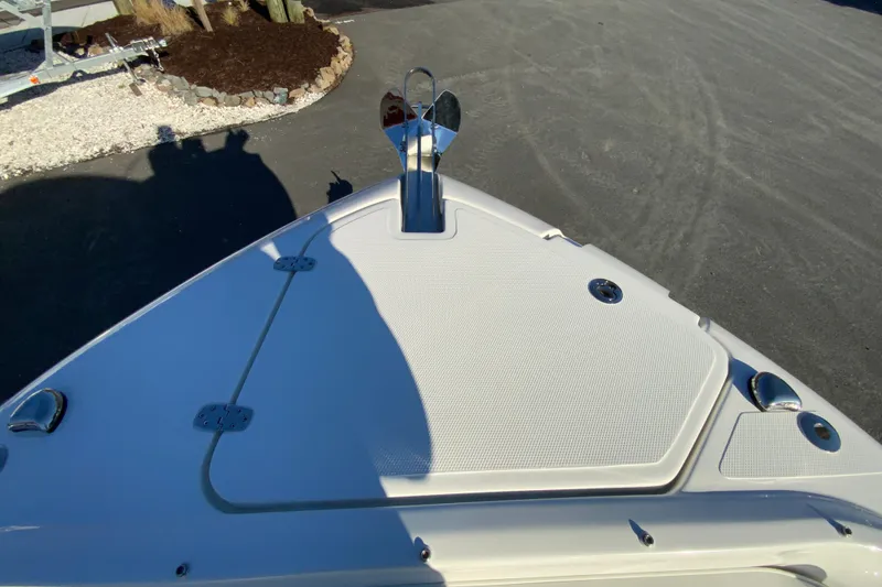 Slide: The Image of 2026 Pursuit DC 246 Dual Console boat bow with anchor, parked on pavement. - 27