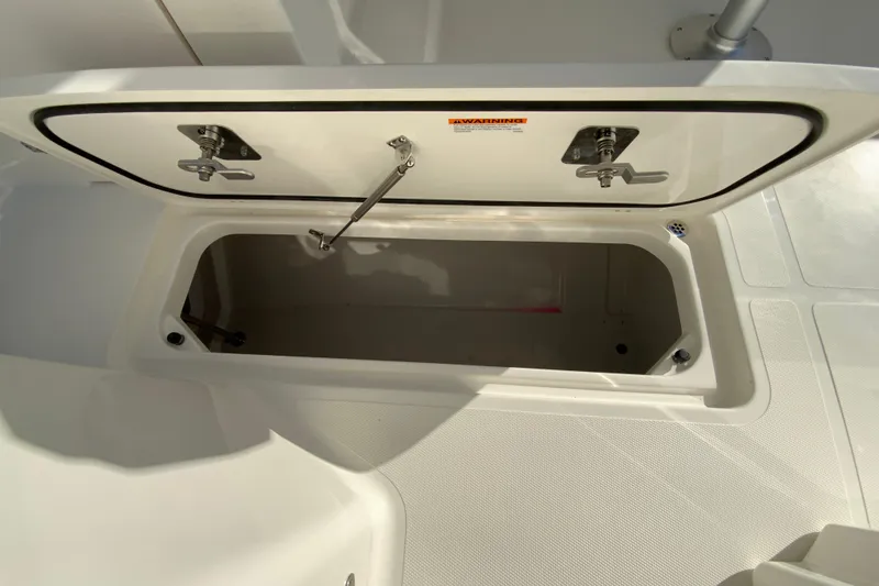 Slide: The Image of 2026 Pursuit DC 246 Dual Console storage compartment open on deck. - 31