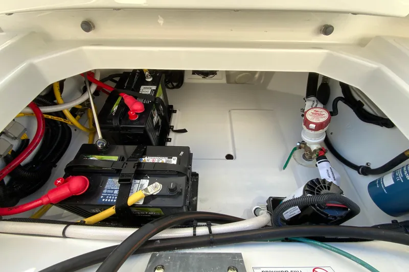 Slide: The Image of 2026 Pursuit DC 246 Dual Console boat battery compartment with wiring and components. - 34