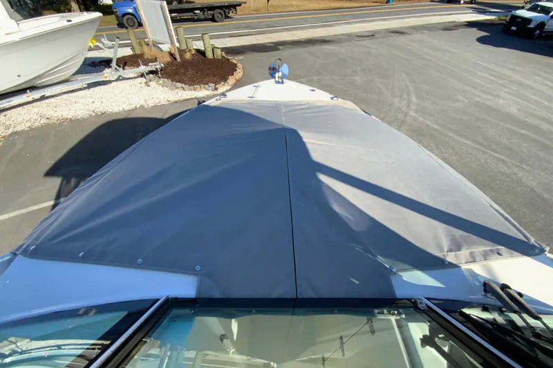 Slide: The Image of 2026 Pursuit DC 246 Dual Console boat with covered bow, parked on pavement. - 41