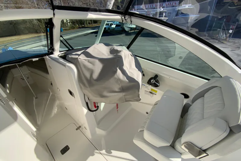 Slide: The Image of 2026 Pursuit DC 246 Dual Console interior with covered helm and cushioned seating. - 42